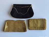 Group shot showing black beaded handbag and two gold clutches