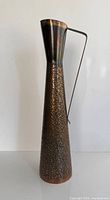 full view of tall conical copper jug