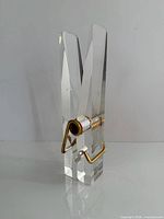 Lucite clothespin standing upright showing clarity and hardware
