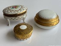 Group shot of all three porcelain trinket boxes showing relative sizes and designs