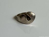 Top angle of sterling silver ring showing curved abstract design