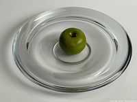 Top view of clear glass bowl with apple for scale