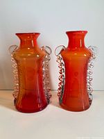 Front view of both orange art glass vases
