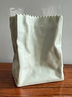 Front view of porcelain bag vase showing overall form and glaze