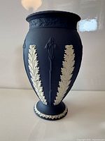 Full view of blue jasperware vase showing white acanthus leaf relief