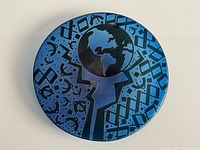 Top view of blue glass charger with abstract globe design