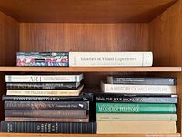 Two shelves showing full lot of books including patterned art volume and Varieties of Visual Experience on top, main stacks below