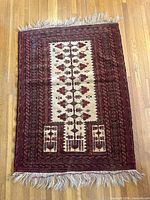 Full view of Baluch rug showing overall design, colors, and fringe