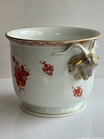 Front view showing floral motif and one ram’s head handle