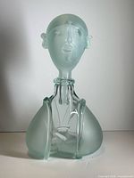 Full view of sculptural art glass bottle showing male head stopper and body