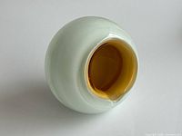 Overall view showing off-white spherical body and orange interior