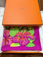 Hermes box partially opened showing folded scarf inside