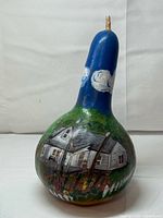 Full view of painted gourd showing overall artwork and broken stem