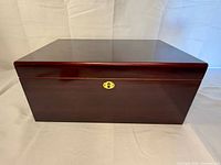 Closed humidor front view showing wood finish and lock plate