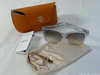 Full set: sunglasses, orange case, beige pouch, booklet