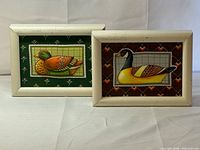 Both framed needlework panels side by side