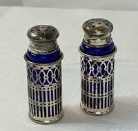 Two assembled shakers standing upright showing lattice sleeves and lids