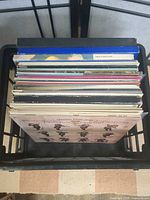 Overhead view of black plastic crate filled with LP records
