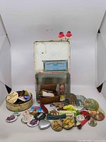 Overall lot view with metal case, buttons, figurines, tools displayed