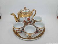 Full tea set showing teapot, four cups and tray with dragon and phoenix design