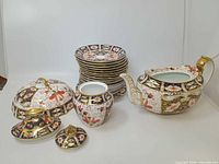 Group shot showing all Imari pieces including plates, teapot, sugar bowl and covered dish