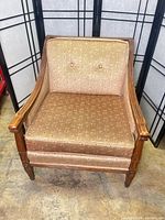 Front view showing full armchair, upholstery pattern, wood frame