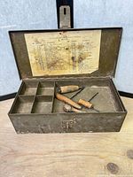 Toolbox open showing tray compartments and three wooden-handled screwdrivers
