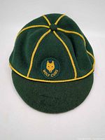 Front view of green Wolf Cubs cap showing yellow piping and badge