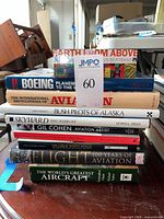 Stack of nine aviation-related hardcover books with spines showing titles