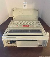 Front view of Brother AX-350 typewriter with cover opened, showing keyboard and paper carriage