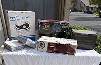 Five boxed car-audio products displayed on table