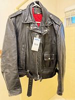 Front view of jacket on hanger showing overall design, belt, tag, and lining glimpse