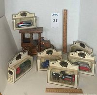Full lot overview with six boxed Chevron vehicles and Model T music box behind