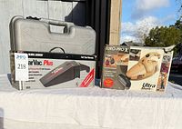 Retail boxes of Black & Decker CarVac Plus and Euro-Pro Ultra Shark