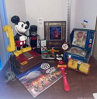 Full lot showing Mickey telephone, watches, book, frame, ornaments, clock, tumbler, and small memorabilia