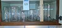 Shelf view showing upside-down double-walled glasses and mug with handle beside ruler for scale