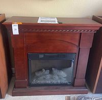 Front view of electric fireplace within wood mantel