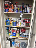 Full cabinet showing multiple shelves of automotive chemicals, fluids and aerosols