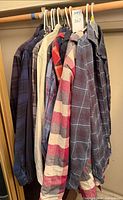 Row of plaid flannel shirts on hangers