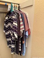 Group of shirts on hangers showing variety of patterns and colors