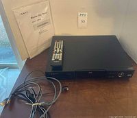 Front view showing player, remote, cables, manual