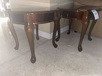 pair of round wooden end tables side by side