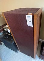 Front and side view of one speaker with grille visible