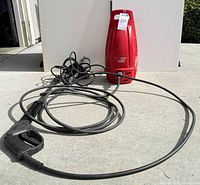Front view of red 1400 electric pressure washer with hose and spray gun laid out