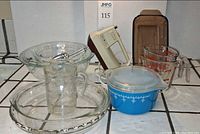 Overall lot showing mixer, blue casserole, measuring cups, mixing bowls, pie plates, baking dish