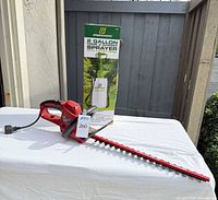 Overall lot view showing hedge trimmer and boxed sprayer