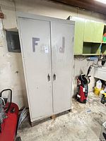 Front view of tall light gray two-door steel cabinet showing "FOOD only" writing and overall condition