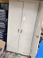 Front view of tall light-gray steel cabinet with two locking handles