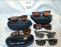 Group shot of six pairs sunglasses and three cases