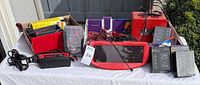 Overall view showing all battery chargers, testers, multimeters and accessories laid out on table